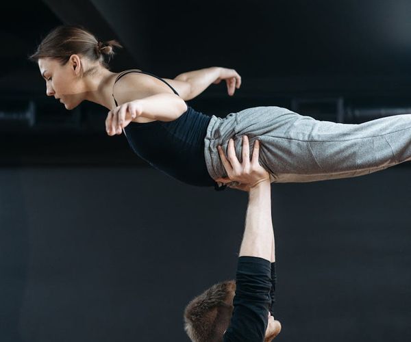 Man maintaining a difficult balance pose, showing focus and control.